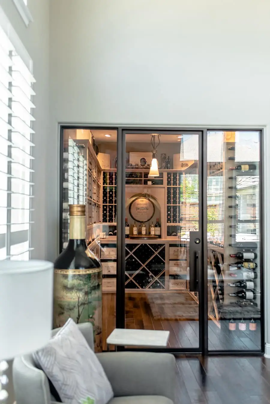 view from outside of a contemporary wine cellar with glass doors and wood wine racks in dallas