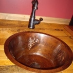 Copper sink with grape design.