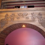 Hand Carved grapevine design on arch with BIG bottle horizontal display above
