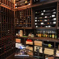 The finished custom wine room, complete with counter and table for wine tasting. Incredible storage and displays were also built with wood to the client\'s specific  needs.