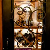 Beautifully crafted wine cellar glass door with iron inlay and a fancy design.