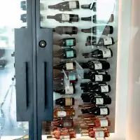 A glass wine cellar door protects and displays the wine collection.
