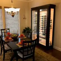 A freestanding wine cabinet enclosed in wood and glass is the perfect compliment to this dining room.