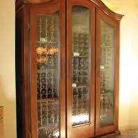 This custom cabinet features stained wood trim and cork-forward wooden racking.