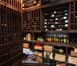The finished custom wine room, complete with counter and table for wine tasting. Incredible storage and displays were also built with wood to the client's specific needs.