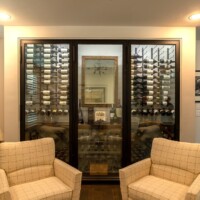 14 - Stained and lacquered alderwood racks make up the bottom section of this small wine cellar design.